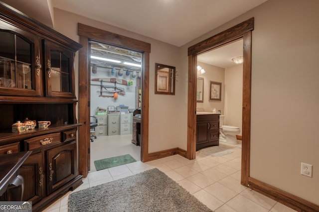hall with baseboards and light tile patterned flooring