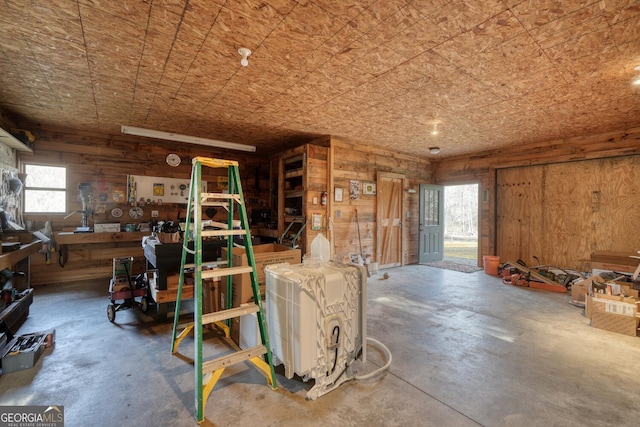 miscellaneous room with wooden walls and concrete flooring