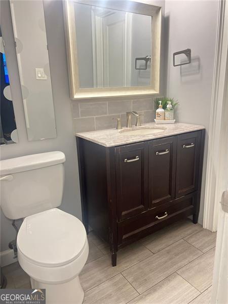 3629 Embry Cir, Atlanta, GA 30341 - bathroom featuring wood tiled floor, tasteful backsplash, toilet, and vanity