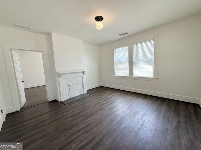 30 Poplar St, Porterdale, GA 30014 - unfurnished living room featuring visible vents, baseboards, and dark wood-style flooring