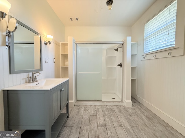 30 Poplar St, Porterdale, GA 30014 - bathroom featuring a shower stall, wood finished floors, vanity, baseboards, and visible vents