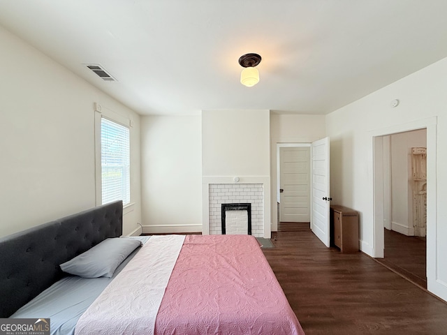 30 Poplar St, Porterdale, GA 30014 - bedroom featuring dark wood finished floors, baseboards, visible vents, and a fireplace
