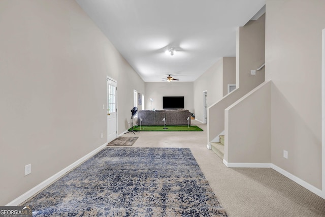 carpeted foyer entrance with a ceiling fan, stairway, and baseboards