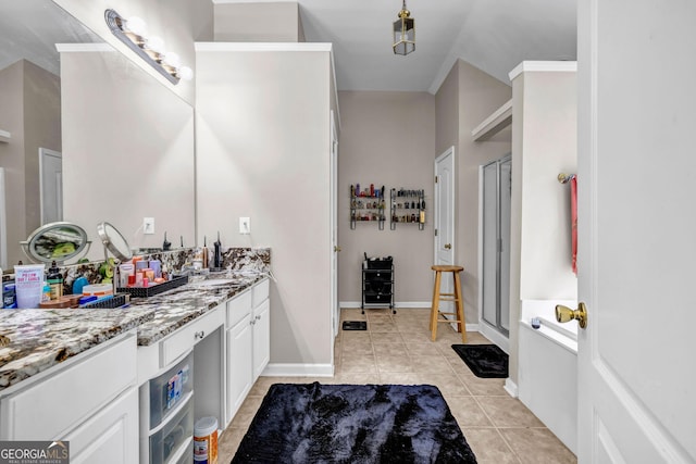 bathroom with tile patterned floors, vanity, a shower stall, and baseboards