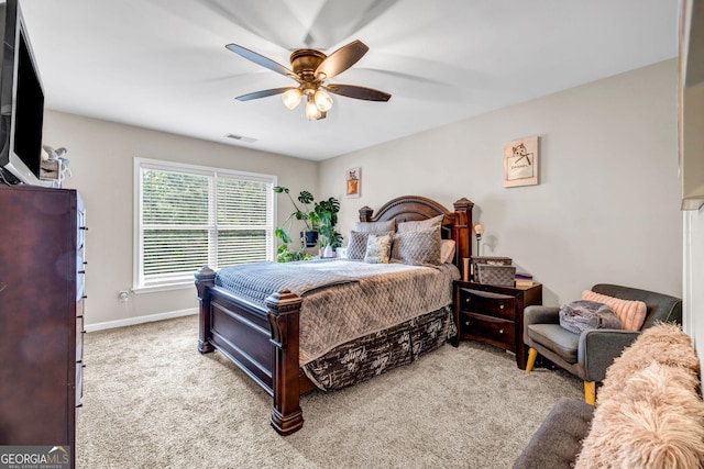 carpeted bedroom with ceiling fan and baseboards