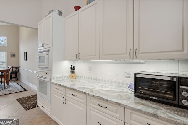 547 E Cardinal Cir, Saint Marys, GA 31558 - kitchen featuring backsplash, white cabinets, white appliances, and light tile patterned floors