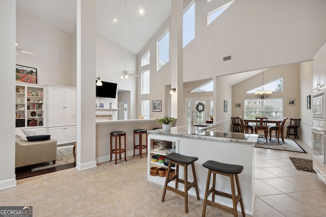 547 E Cardinal Cir, Saint Marys, GA 31558 - kitchen featuring high vaulted ceiling, white cabinets, a breakfast bar, and a sink