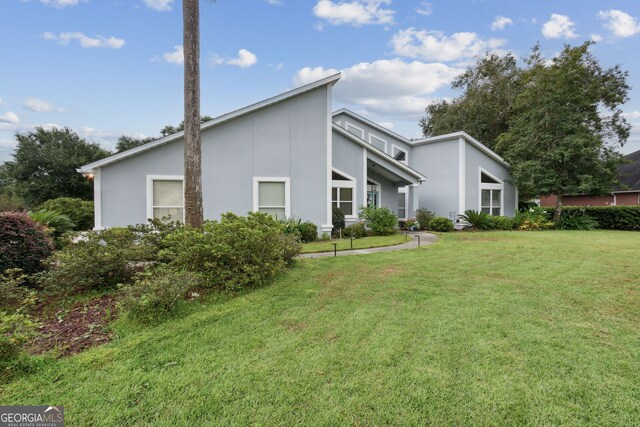 547 E Cardinal Cir, Saint Marys, GA 31558 - view of home's exterior with a lawn and stucco siding