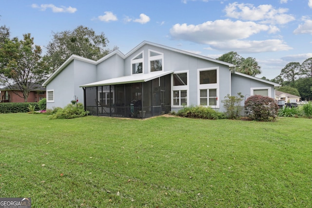 547 E Cardinal Cir, Saint Marys, GA 31558 - back of house with an attached garage, a lawn, a sunroom, and stucco siding