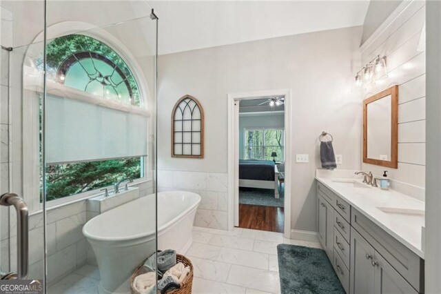 6565 Scottsfield Trce, Cumming, GA 30028 - full bath with a sink, connected bathroom, a freestanding tub, tile walls, and double vanity