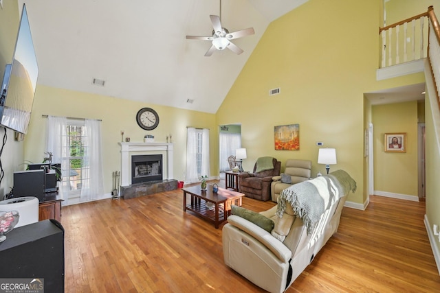 living area with light wood-type flooring, visible vents, high vaulted ceiling, and ceiling fan
