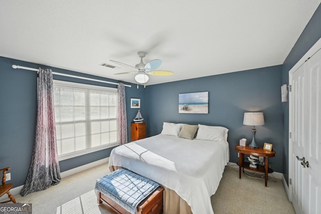 bedroom featuring light carpet, a ceiling fan, baseboards, and a closet