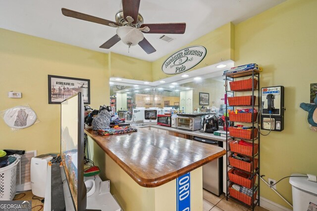 kitchen with refrigerator, a ceiling fan, light tile patterned floors, a peninsula, and baseboards
