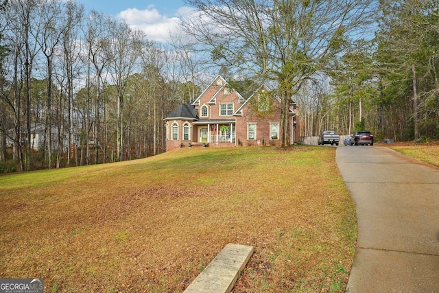 traditional-style home featuring a front yard and concrete driveway