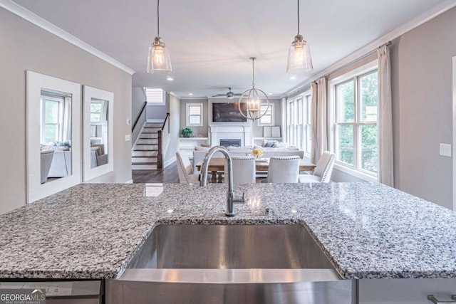 2675 Sugar Mill Dr, Atlanta, GA 30316 - kitchen with ornamental molding, light stone countertops, a fireplace, open floor plan, and a sink