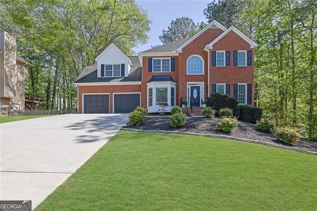 colonial home featuring a garage, driveway, a front yard, and brick siding