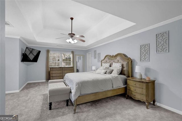 carpeted bedroom featuring a tray ceiling, visible vents, ornamental molding, baseboards, and ceiling fan