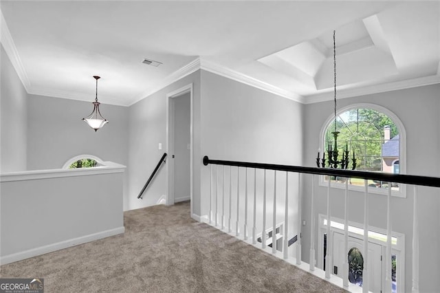 hall with carpet, a tray ceiling, visible vents, an upstairs landing, and crown molding