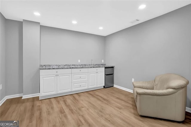 sitting room featuring visible vents, baseboards, light wood finished floors, and recessed lighting