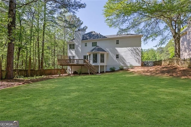 rear view of property featuring a chimney, stairs, a fenced backyard, a lawn, and a deck