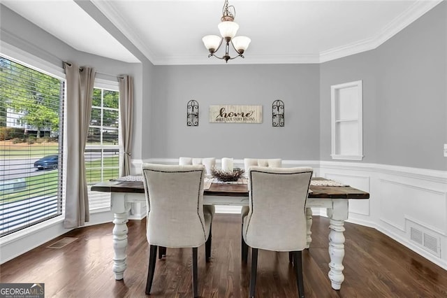 dining room featuring an inviting chandelier, crown molding, a wainscoted wall, and visible vents