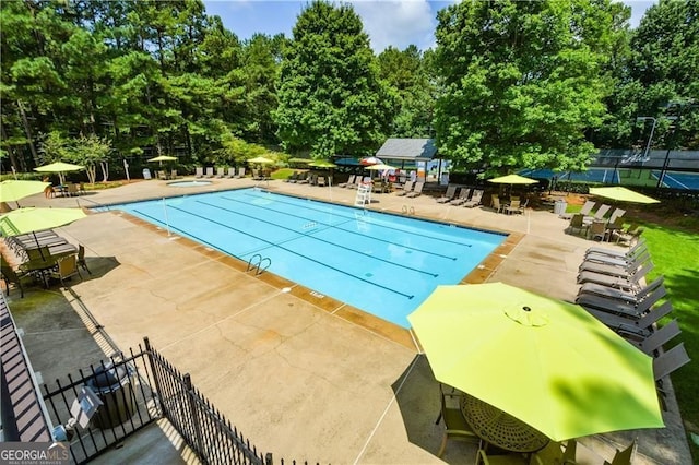 community pool featuring fence and a patio area
