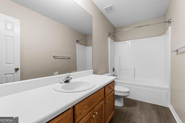 203 Old Pond Dr W, Kingsland, GA 31548 - bathroom with toilet, wood finished floors, vanity, a textured ceiling, and bathing tub / shower combination