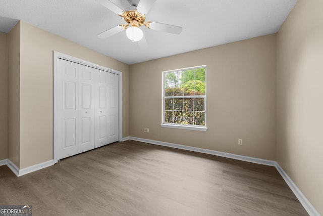 203 Old Pond Dr W, Kingsland, GA 31548 - unfurnished bedroom featuring wood finished floors, baseboards, a closet, and a ceiling fan
