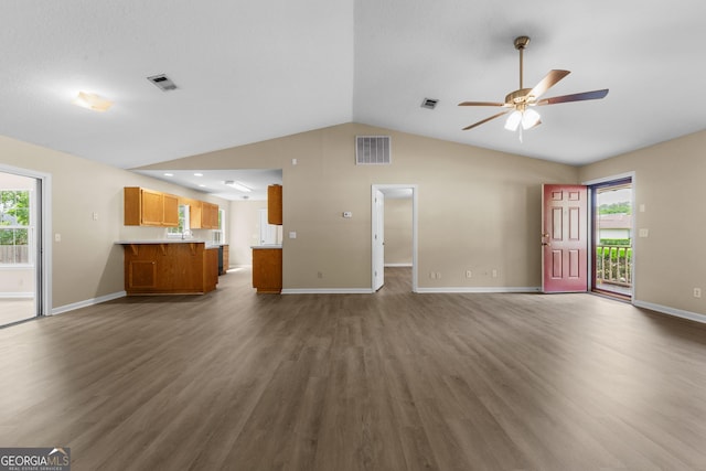 203 Old Pond Dr W, Kingsland, GA 31548 - unfurnished living room with a ceiling fan, vaulted ceiling, wood finished floors, baseboards, and plenty of natural light