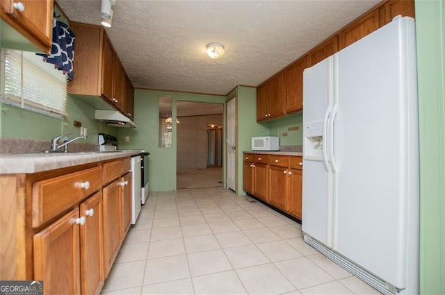 1530 Mcbrayer, Temple, GA 30179 - kitchen featuring white appliances, a textured ceiling, brown cabinetry, light countertops, and light tile patterned floors
