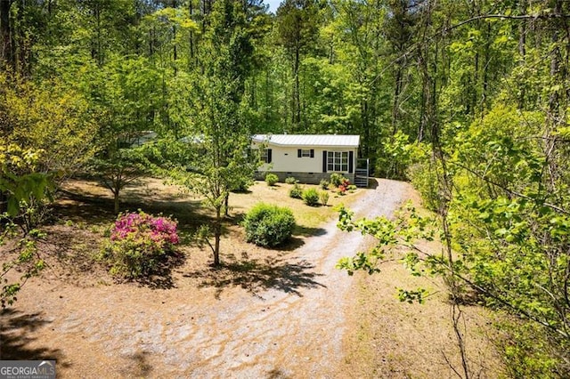 1530 Mcbrayer, Temple, GA 30179 - view of front of house with a wooded view, driveway, and metal roof