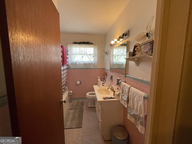 1105 College St, Bainbridge, GA 39819 - full bathroom featuring vanity, tub / shower combination, toilet, tile walls, and a wainscoted wall