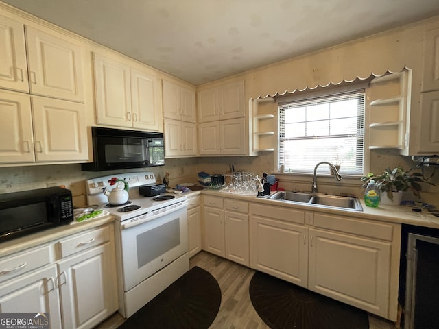 1105 College St, Bainbridge, GA 39819 - kitchen with black microwave, open shelves, electric range, and a sink