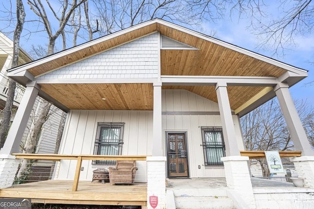 doorway to property featuring board and batten siding and covered porch