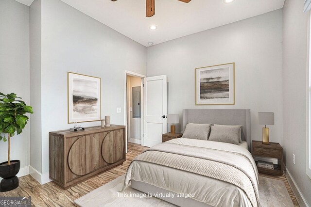 bedroom with light wood finished floors, a ceiling fan, baseboards, and recessed lighting