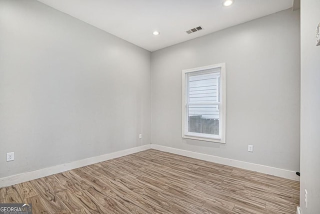 empty room featuring baseboards, wood finished floors, visible vents, and recessed lighting