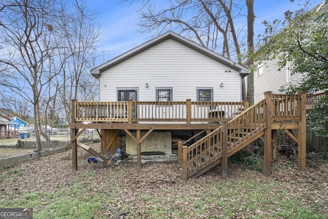 back of house featuring fence, a wooden deck, and stairway