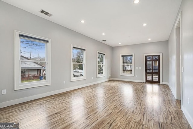 unfurnished living room featuring visible vents, baseboards, wood finished floors, and recessed lighting