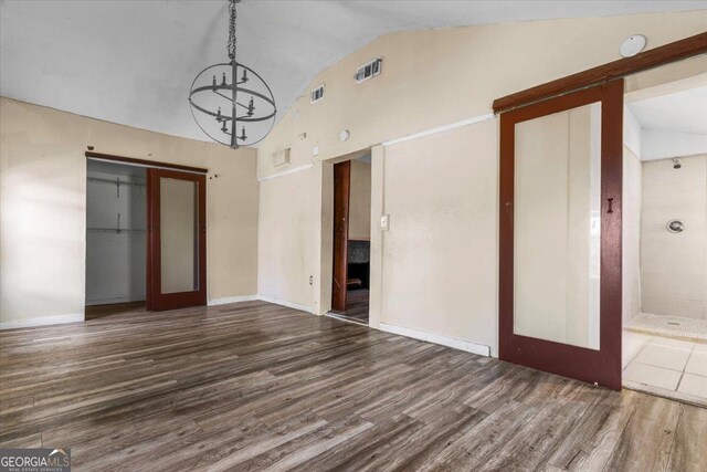 602 W Lake Ave NW, Atlanta, GA 30318 - unfurnished dining area featuring high vaulted ceiling, wood finished floors, baseboards, a notable chandelier, and visible vents