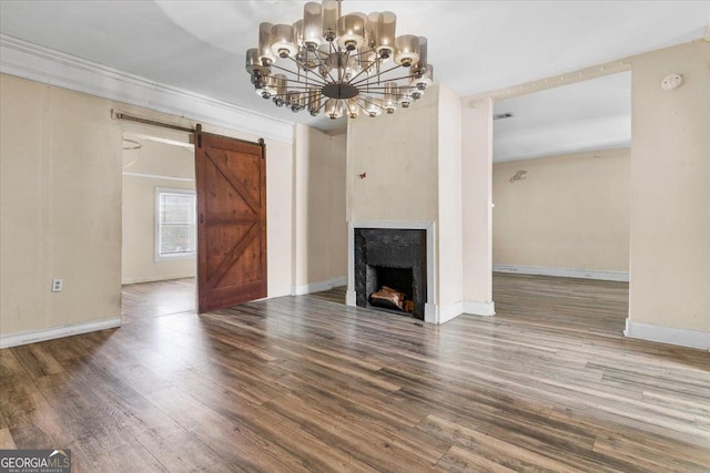 602 W Lake Ave NW, Atlanta, GA 30318 - unfurnished living room featuring a barn door, baseboards, and wood finished floors