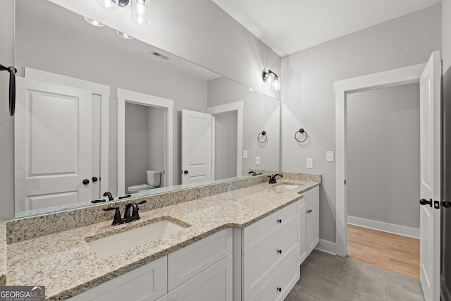 2000 Millstream Ct, Griffin, GA 30224 - bathroom with baseboards, a sink, double vanity, and toilet