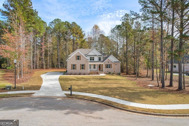2002 Millstream Ct, Griffin, GA 30224 - traditional home with a front yard, a wooded view, and concrete driveway