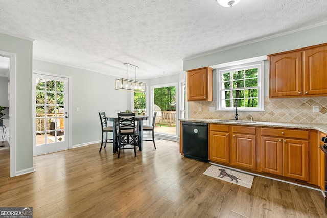 kitchen featuring a sink, decorative backsplash, black dishwasher, and brown cabinets