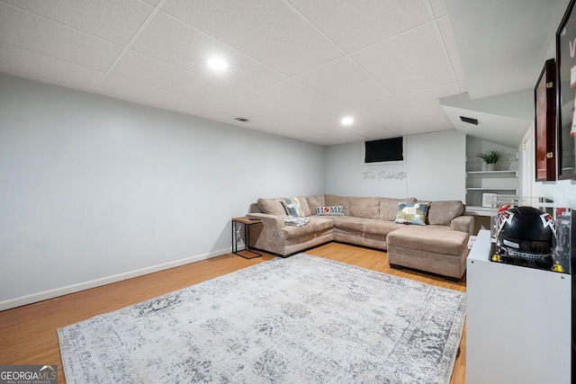 living area with baseboards, recessed lighting, a paneled ceiling, and wood finished floors