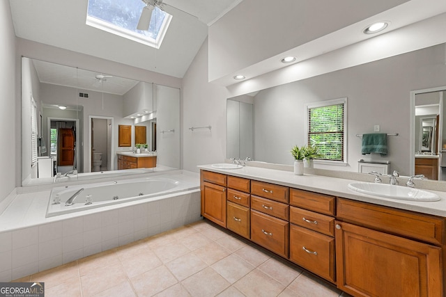 full bathroom with double vanity, a sink, a tub with jets, and toilet
