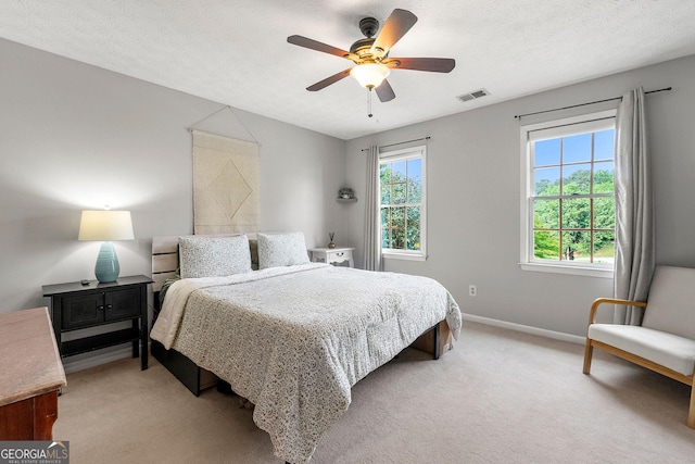 bedroom featuring baseboards, ceiling fan, light colored carpet, and visible vents