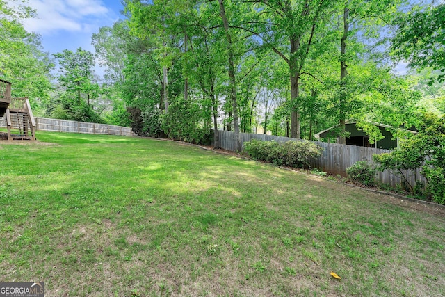 view of yard with stairs and a fenced backyard