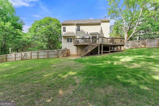 back of house with stairway, a deck, a yard, and a fenced backyard