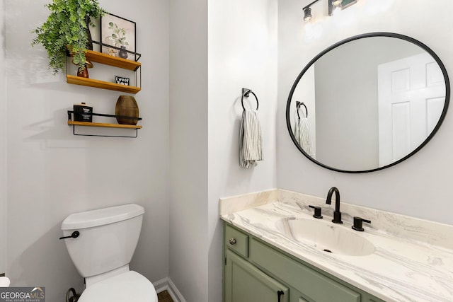 bathroom featuring vanity, baseboards, and toilet