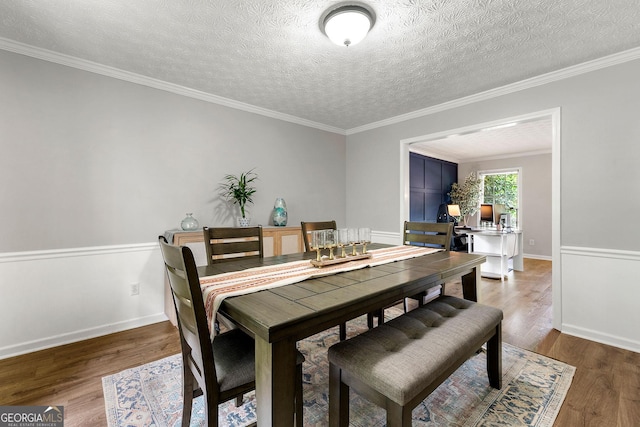 dining area with crown molding, baseboards, and wood finished floors